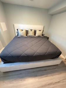 a bedroom with a large black bed with pillows at Cozy ATL Suite with Kitchenette in Atlanta