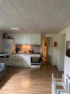 a kitchen with white appliances and a table and chairs at Room in a shared apartment in Trondheim