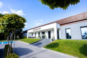 a large white building with a lawn in front of it at Arboretum Hotel in Wolbórz