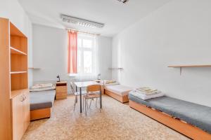 a room with two beds and a table at Apartmány Nerudova in Vítkovice