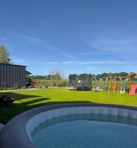 a backyard with a hot tub and a playground at Morze u Sary - Wrzosowo 361, Dziwnówek in Dziwnówek