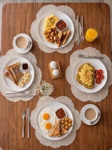 a table with plates of breakfast food on it at Magnolia Suites B&B in Dar es Salaam
