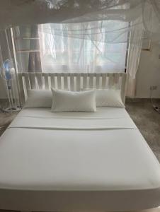 a large white bed in a room with a window at Kilifi Hideaway,Spacious Coastal Retreat in Kilifi