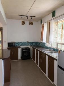 a kitchen with a sink and a stove at Kilifi Hideaway,Spacious Coastal Retreat in Kilifi