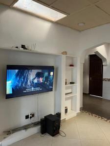 a flat screen tv on a wall in a living room at Kilifi Hideaway,Spacious Coastal Retreat in Kilifi