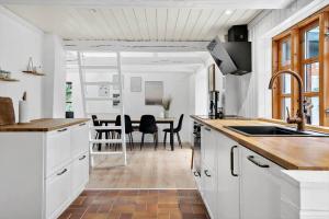 a kitchen with white cabinets and a dining room at LF11124-Struer-Vesterkaervej-24 in Struer