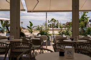 a restaurant with tables and chairs with a view of the ocean at Hotel Miramare in Porto Cesareo