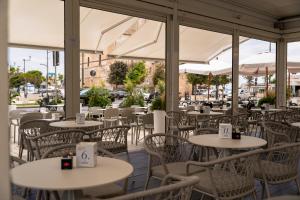 an empty restaurant with tables and chairs with umbrellas at Hotel Miramare in Porto Cesareo