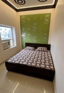 a bed in a room with a green wall at Hotel rahul prime in Gogameri