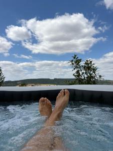 a man laying in a jacuzzi in a swimming pool at Domaine d'Equital'Or in Cressanges