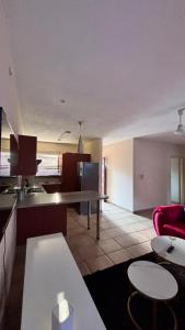 a kitchen and living room with a table and chairs at Success Guesthouse in Nelspruit