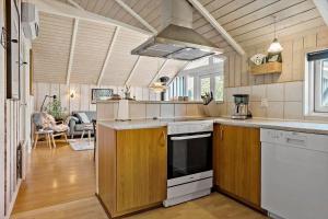 a kitchen with a stove top oven next to a living room at LF328-Vestervig-Gunhildsvej-28 in Vestervig