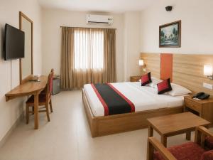 a hotel room with a bed and a desk at Hotel Supreme in Sylhet
