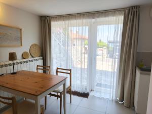 a dining room with a table and a large window at Vila Flori in Koper