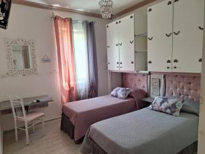 a bedroom with two beds and a desk and cabinets at DolceMorfeo in Olbia