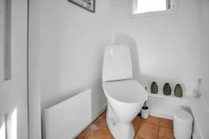 a white bathroom with a toilet in the corner at 10040-Rorvig-Lyngvaenget-10 in Rørvig