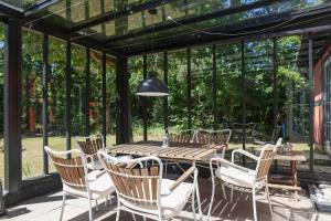 a conservatory with a wooden table and chairs at 10040-Rorvig-Lyngvaenget-10 in Rørvig