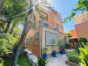 a house with a palm tree in front of it at Atlas View Luxury Villa in Ourika