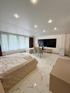 a large bedroom with a large bed and a desk at Mirali Resort in Almaty