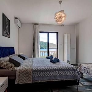 a bedroom with a bed and a large window at Apartmani Mila in Ubli