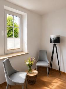 two chairs and a table in a room with a window at Villa Jeziorki in Warsaw