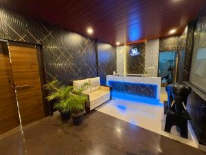 a living room with a couch and a shower at Hotel La Gowri, Coorg in Madikeri