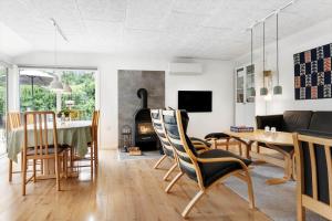 a living room with a table and chairs and a fireplace at LF16121-Farso-Bjarkesvej-11 in Farsø