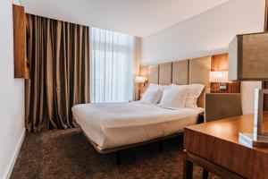 a hotel room with a bed and a desk at Hotel Porto Downtown in Porto +71 photos