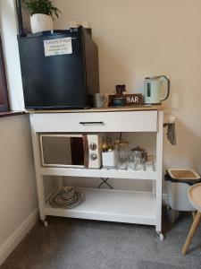 a tv on top of a white tv stand at Rosemount Guest Suite in Grange Over Sands