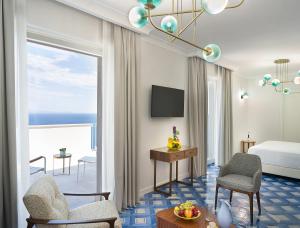 a hotel room with a bed and a view of the ocean at Il Tipografo di Amalfi A Family Museum Hotel in Amalfi