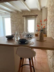a kitchen with a wooden table with wine glasses on it at La Pierre Pourpre in Eymet +8 photos