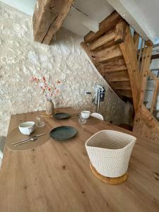 a wooden table with plates and flowers on it at La Pierre Pourpre in Eymet