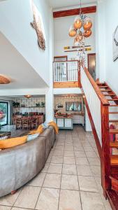 a living room with a couch and a staircase at Buff and Fellow by the Bay in Great Brak River