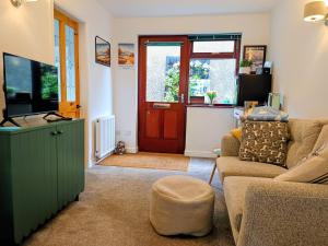 a living room with a couch and a red door at Rosemount Guest Suite in Grange Over Sands