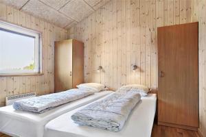 two beds in a room with wooden walls at LF626-Snedsted-Kongens-Borer-4 in Snedsted