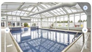 a large swimming pool with a glass ceiling at Seaside Haven Hunstanton 2026 Model in Hunstanton +11 photos