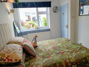 a bedroom with a bed with a comforter and a chicken on it at Rosemount Guest Suite in Grange Over Sands