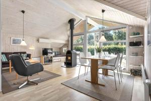a living room with a dining table and a fireplace at LF15147-Farso-Ramshule-47 in Farsø