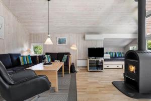 a living room with a couch and a fireplace at LF15147-Farso-Ramshule-47 in Farsø