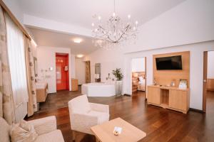 a living room with a chandelier and a bathroom at Relax- & Wanderhotel Poppengut in Hinterstoder