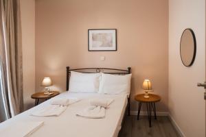a bedroom with a bed with two lamps and a mirror at Traditional House in Mytilene Center in Mytilene