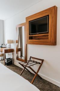 a hotel room with a flat screen tv on a wall at Hotel Porto Downtown in Porto