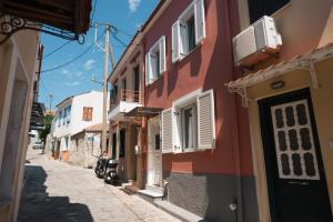 an alley in an old town with pink and white buildings at Traditional House in Mytilene Center in Mytilene