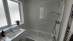 a white bathroom with a shower and a sink at York city centre No7 Agar Street in York