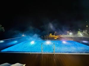 a large swimming pool at night with lights at Happy Place in Poiana Brasov