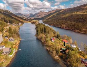 an aerial view of a river in a valley at Tinyhouse surrounding Norwegian mountains in Bergen +11 photos