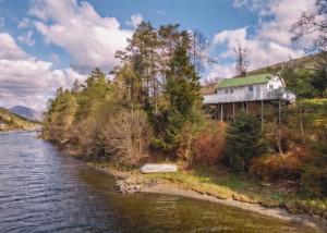 a house on a hill next to a river at Tinyhouse surrounding Norwegian mountains in Bergen
