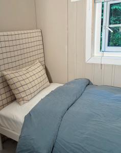 a bed with a pillow and a chair in a room at Tinyhouse surrounding Norwegian mountains in Bergen