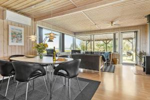 a dining room and living room with a table and chairs at LF15194-Hojslev-Spaettevej-14 in Højslev