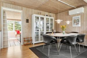 a dining room with a table and black chairs at LF15194-Hojslev-Spaettevej-14 in Højslev